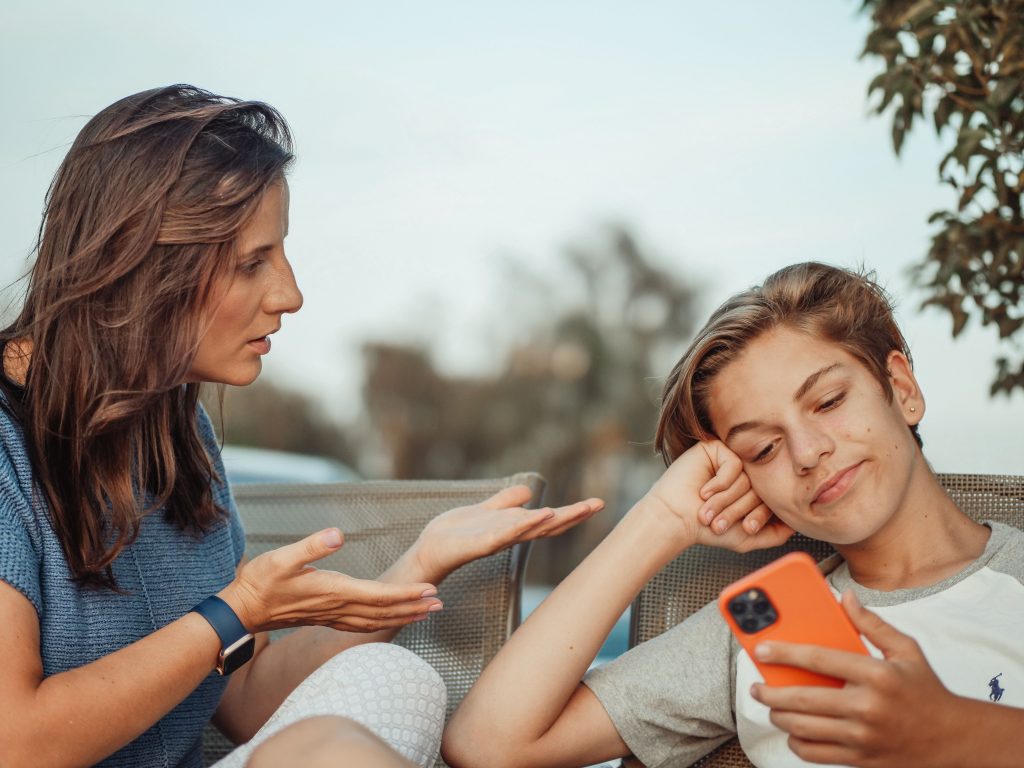 Madre hablando con su hijo adolescente que no quiere ir a terapia